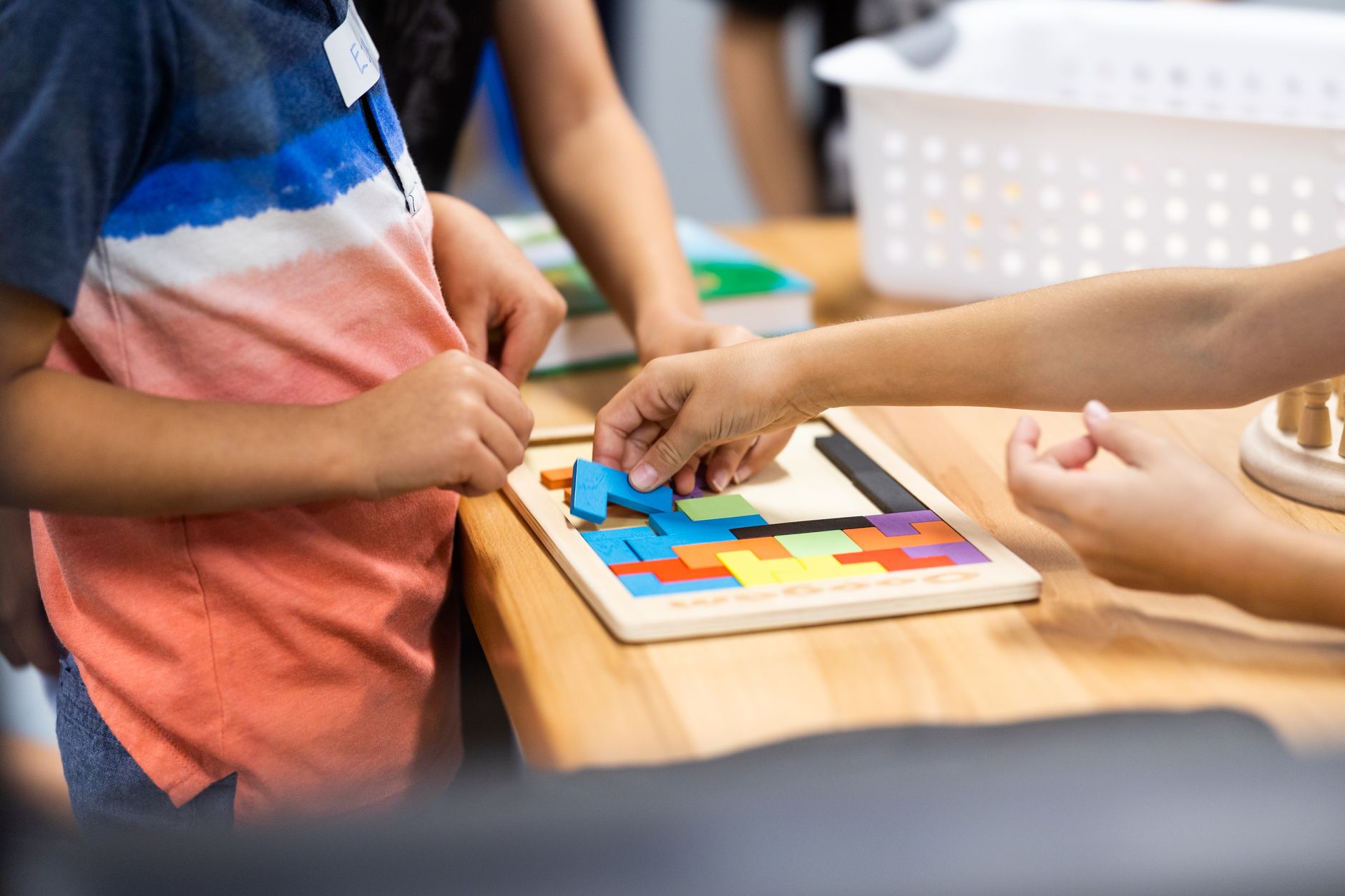 Young children working together over a colorful puzzle on a classroom table
